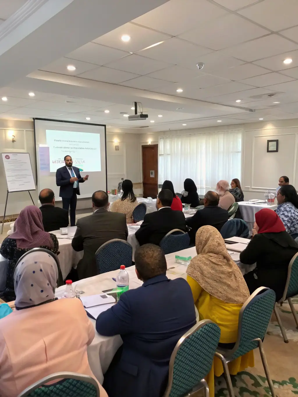 A photo of a diverse team participating in a leadership workshop, engaging in collaborative activities facilitated by a trainer.