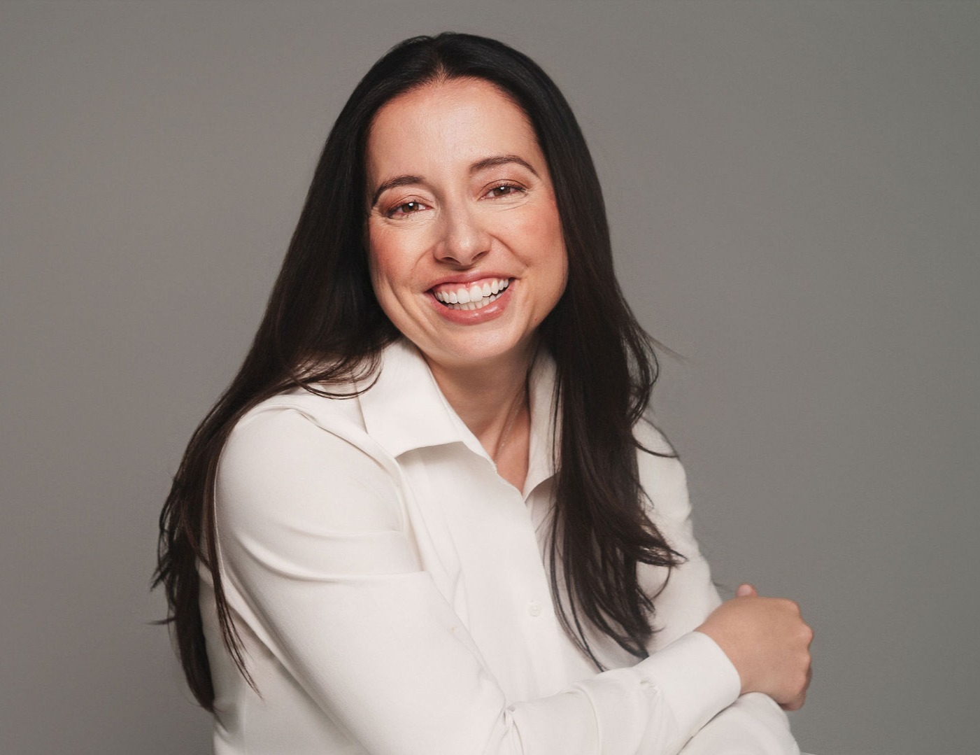 A professional headshot of Ruthann Savage, Founder of Savage Dynamic Consulting, taken in a neutral setting with soft, natural lighting. The founder is smiling confidently, conveying approachability and expertise.